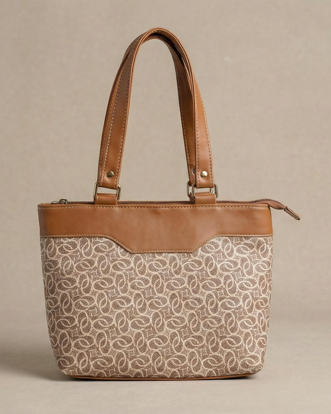 Handbag with patterned front and brown leather accents on a beige background
