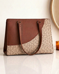 Handbag with brown leather top section and floral patterned fabric base on a white surface.
