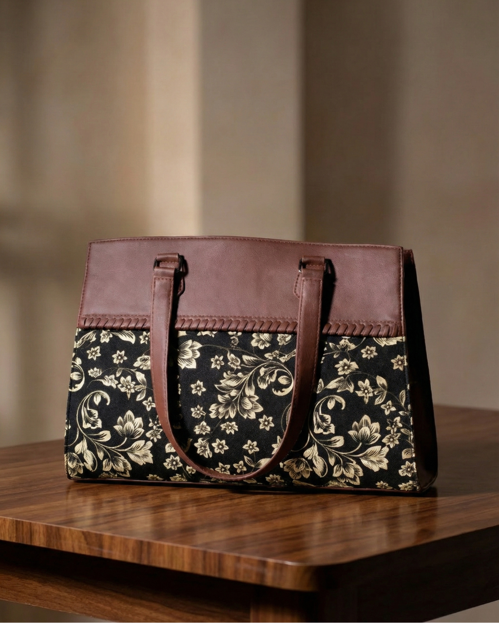 Floral-patterned handbag with brown accents on a wooden surface