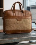 Brown leather and patterned fabric briefcase on a desk