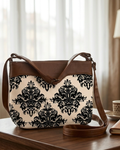 Patterned handbag with brown leather accents on a wooden surface.