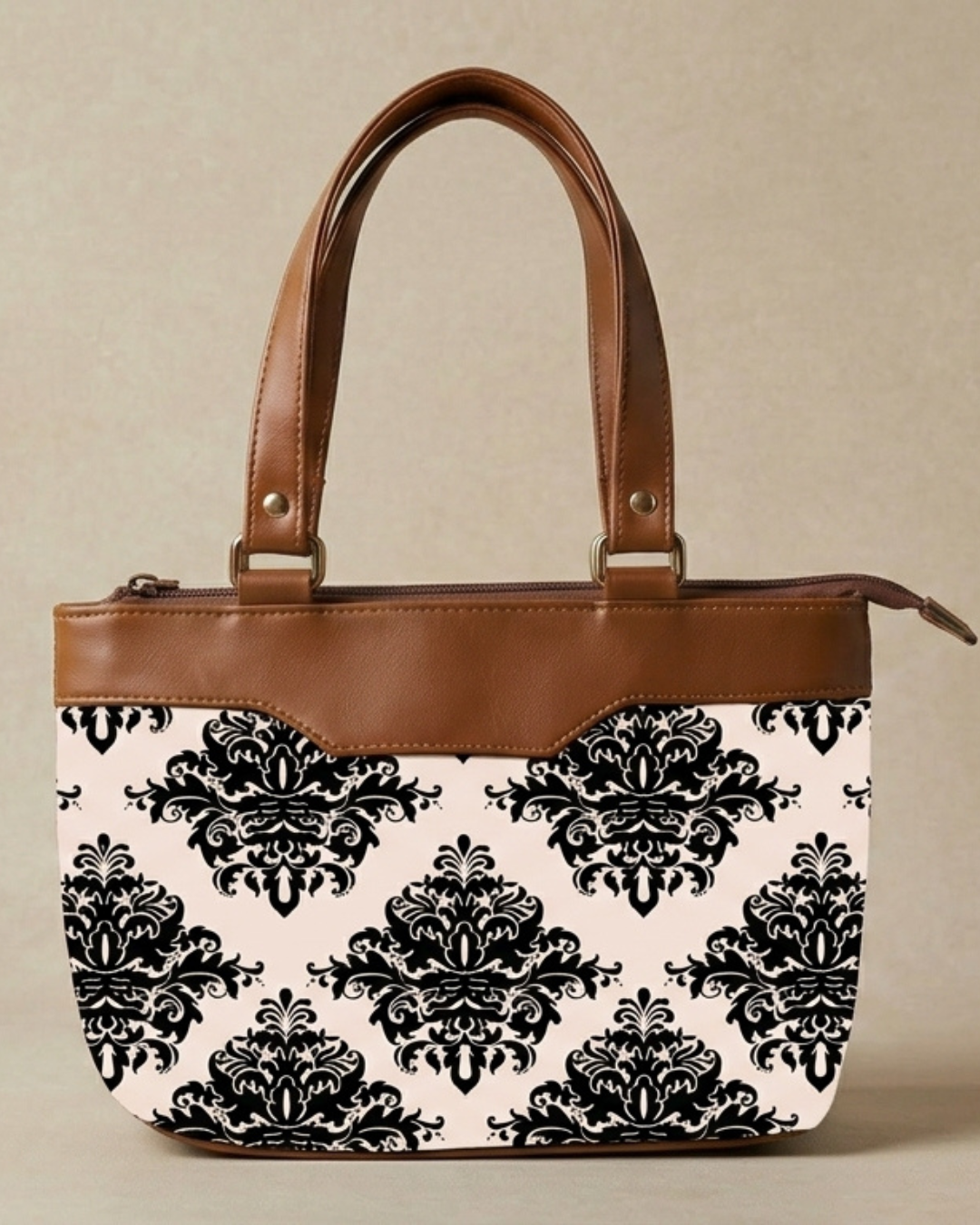 Handbag with black floral pattern on white background and brown leather accents