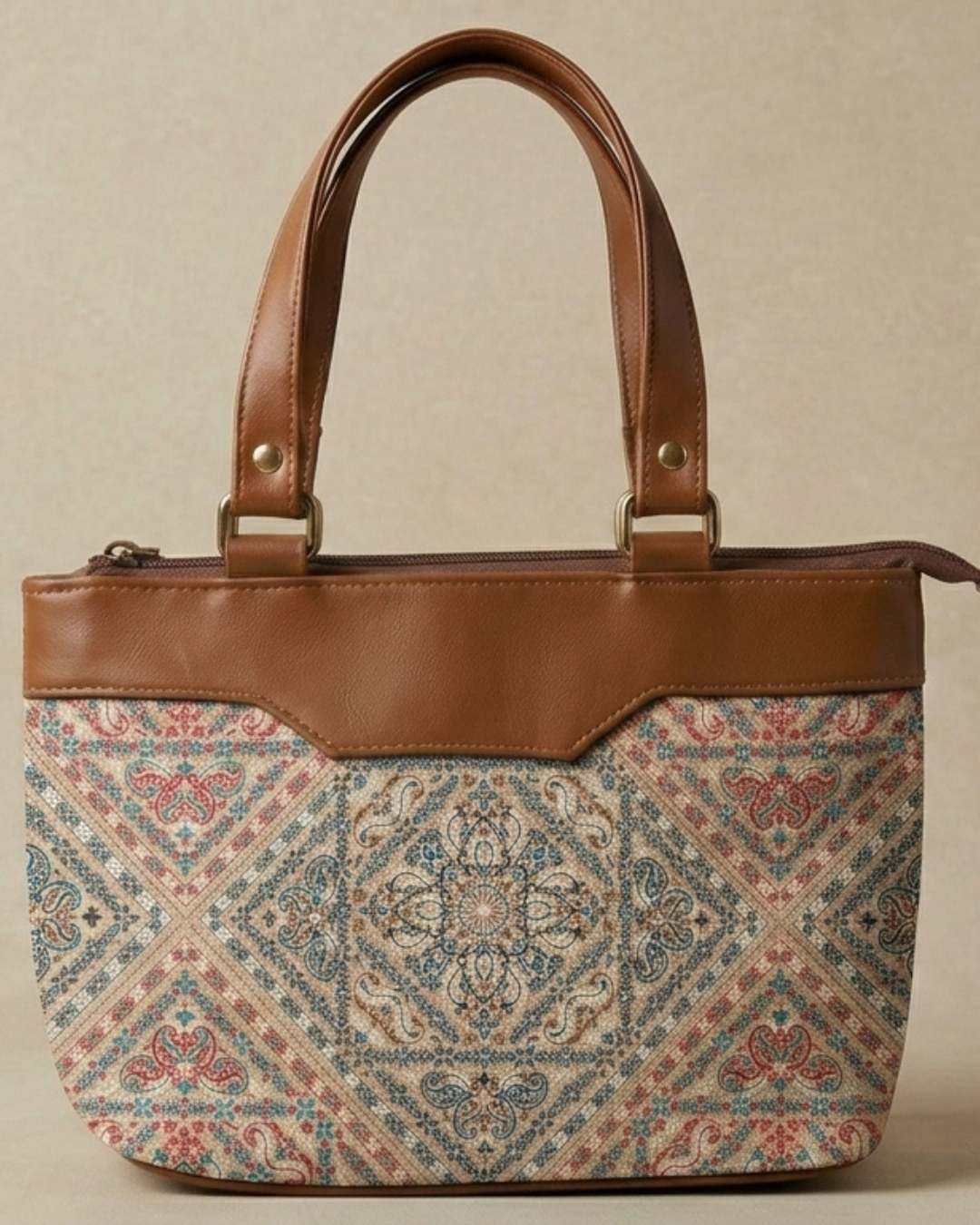 Handbag with patterned front and brown leather accents on a beige background