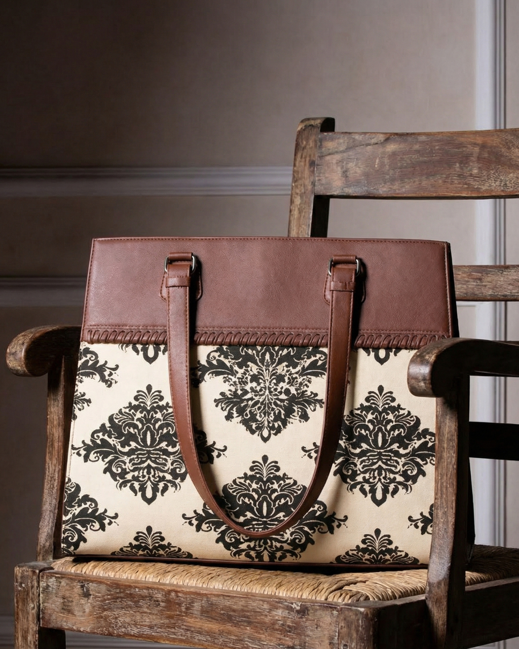 Brown leather handbag with floral pattern on a wooden chair