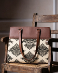 Brown leather handbag with floral pattern on a wooden chair