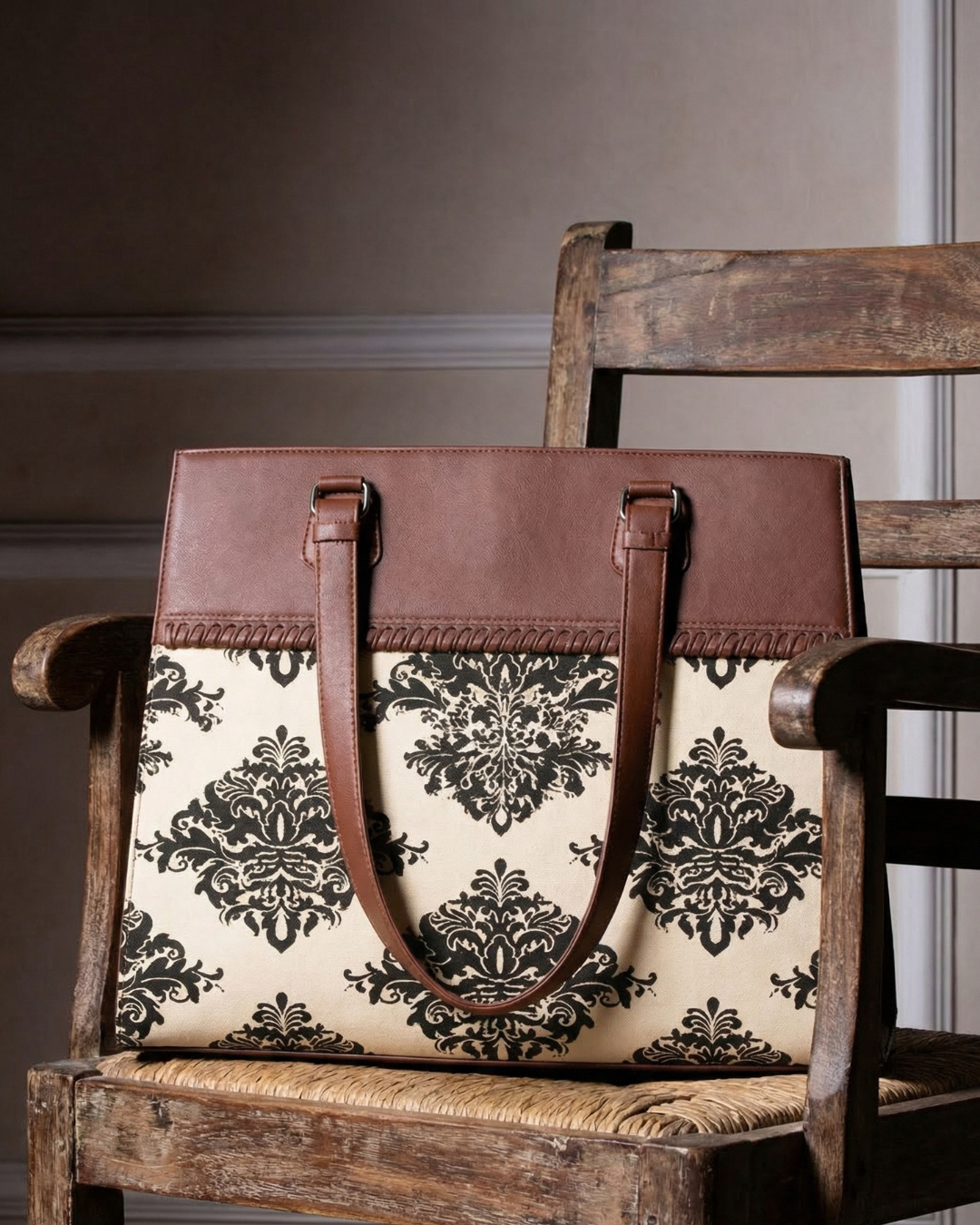 Brown leather handbag with floral pattern on a wooden chair