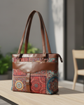 Multicolored patterned handbag with brown accents on a wooden surface.
