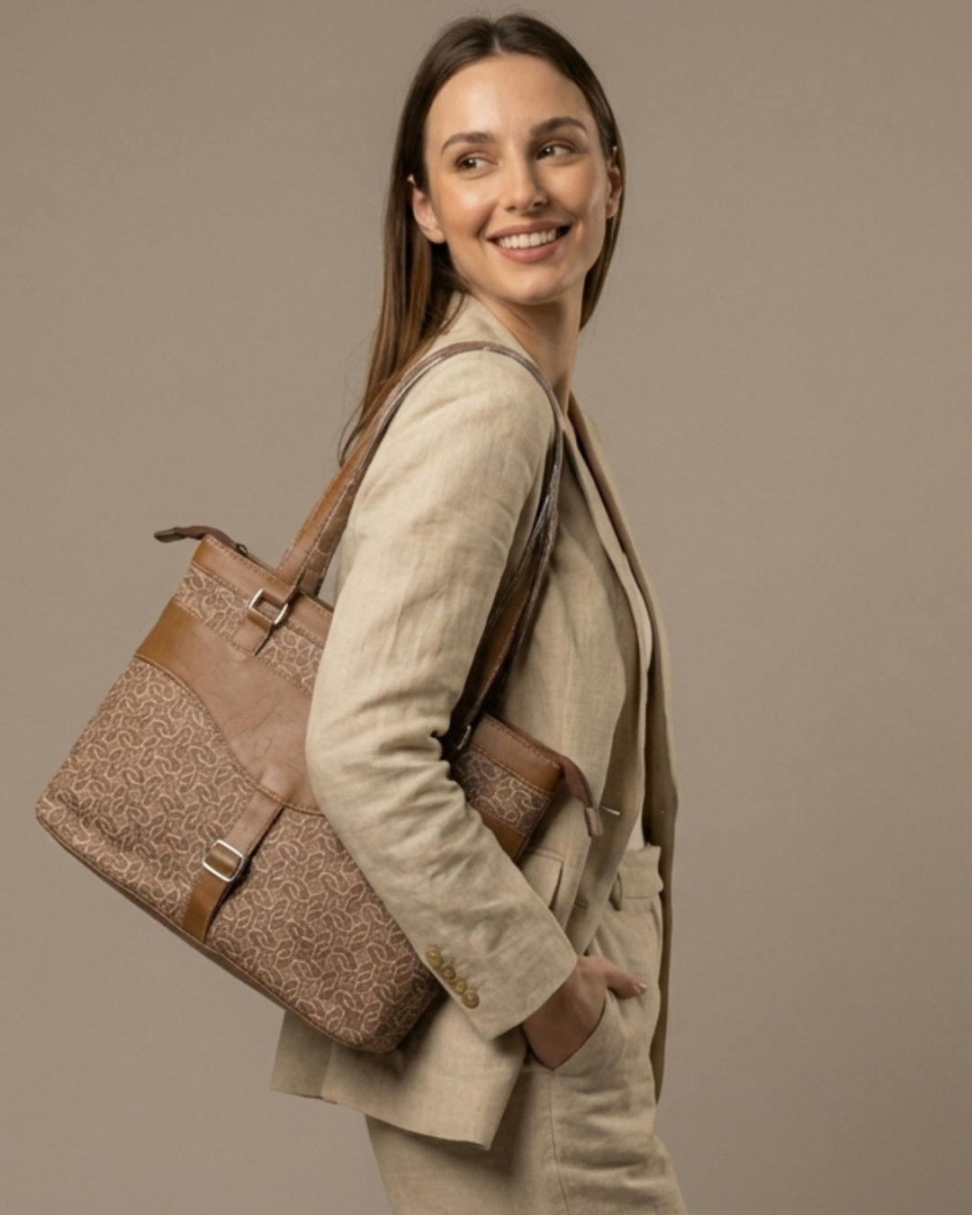 Woman carrying a brown textured handbag against a beige background