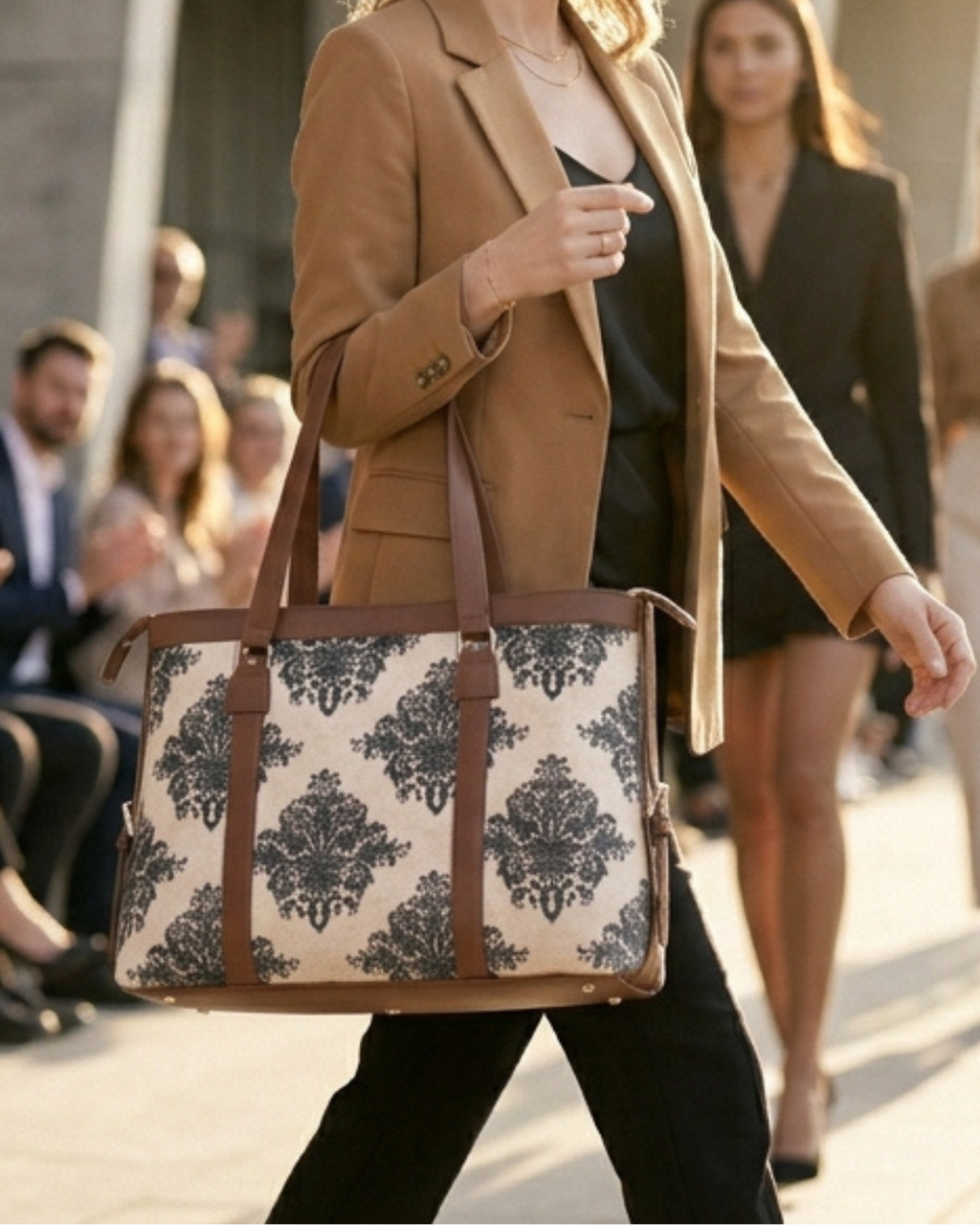 Woman walking outdoors holding a patterned bag, with a blurred background of people.