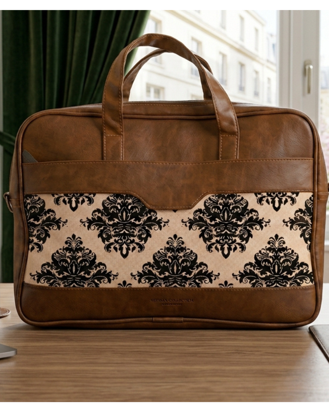 Brown leather briefcase with black floral pattern on a wooden surface