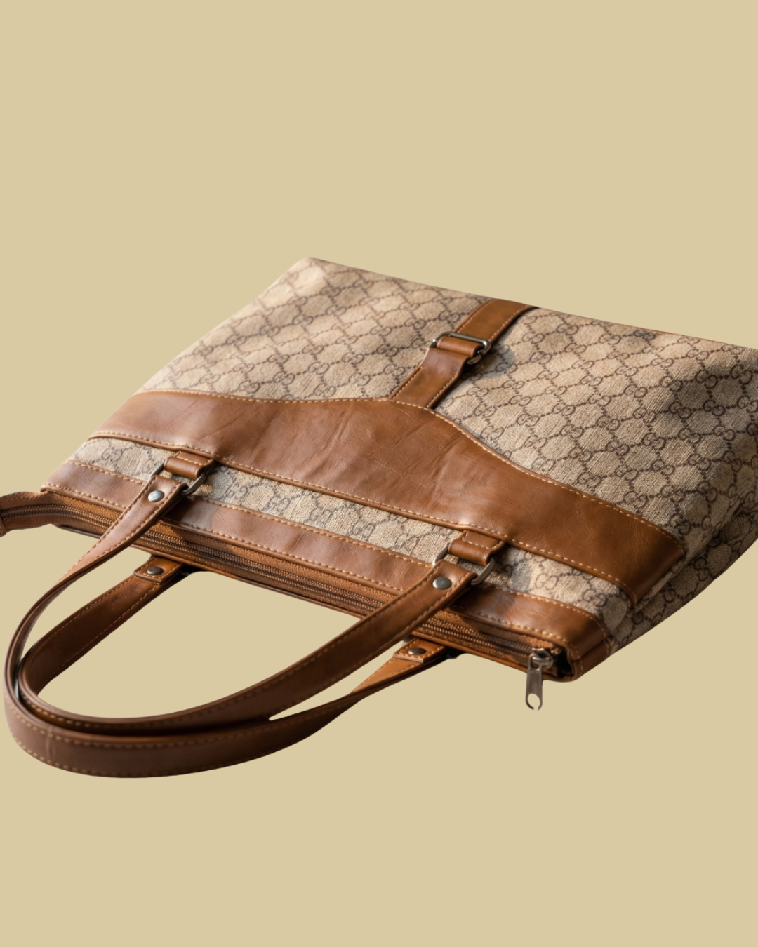 Designer handbag with brown leather accents on a beige background