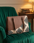 Designer handbag with floral pattern on a green armchair