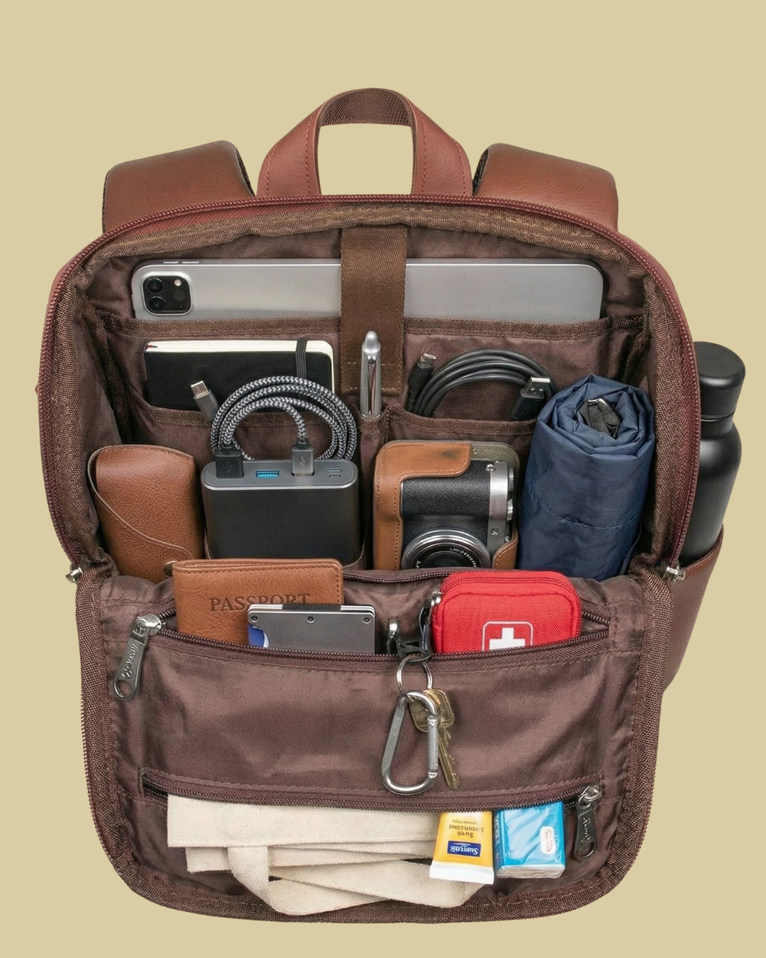 Brown backpack with various items organized inside on a beige background