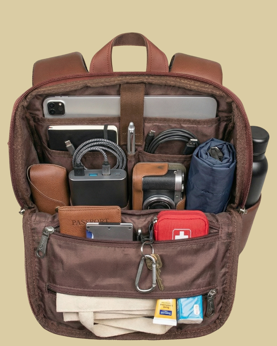 Brown backpack with various items organized inside on a beige background