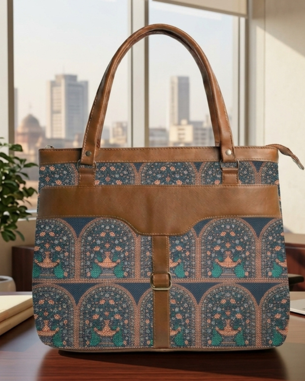 Patterned tote bag with brown leather accents on a desk with a cityscape in the background