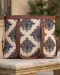 Patterned bag with brown straps on a stone surface