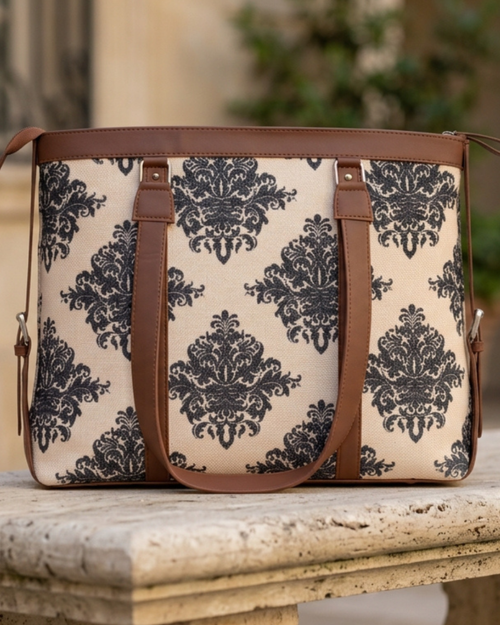 Patterned bag with brown straps on a stone surface