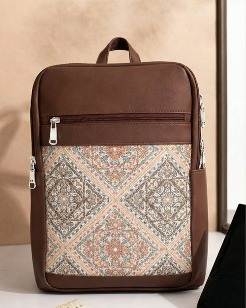 Brown backpack with patterned front panel on a beige background